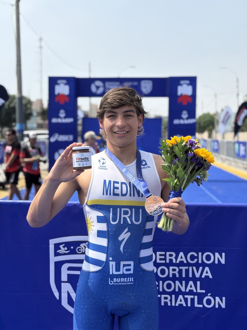 Elías Medina en el podio de la Americas Triathlon Cup con un frasco de Fittella